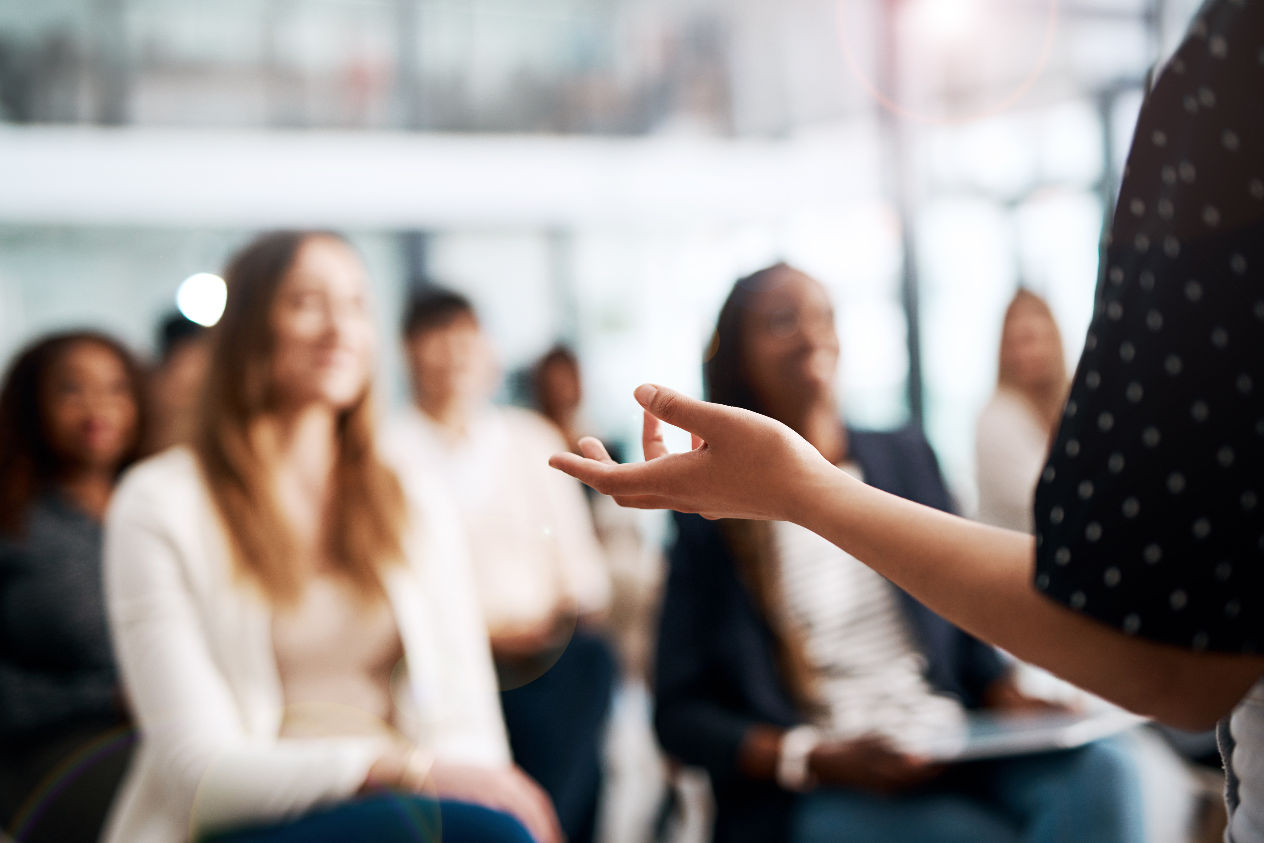 Group of business women smiling and listening to the speaker during seminar