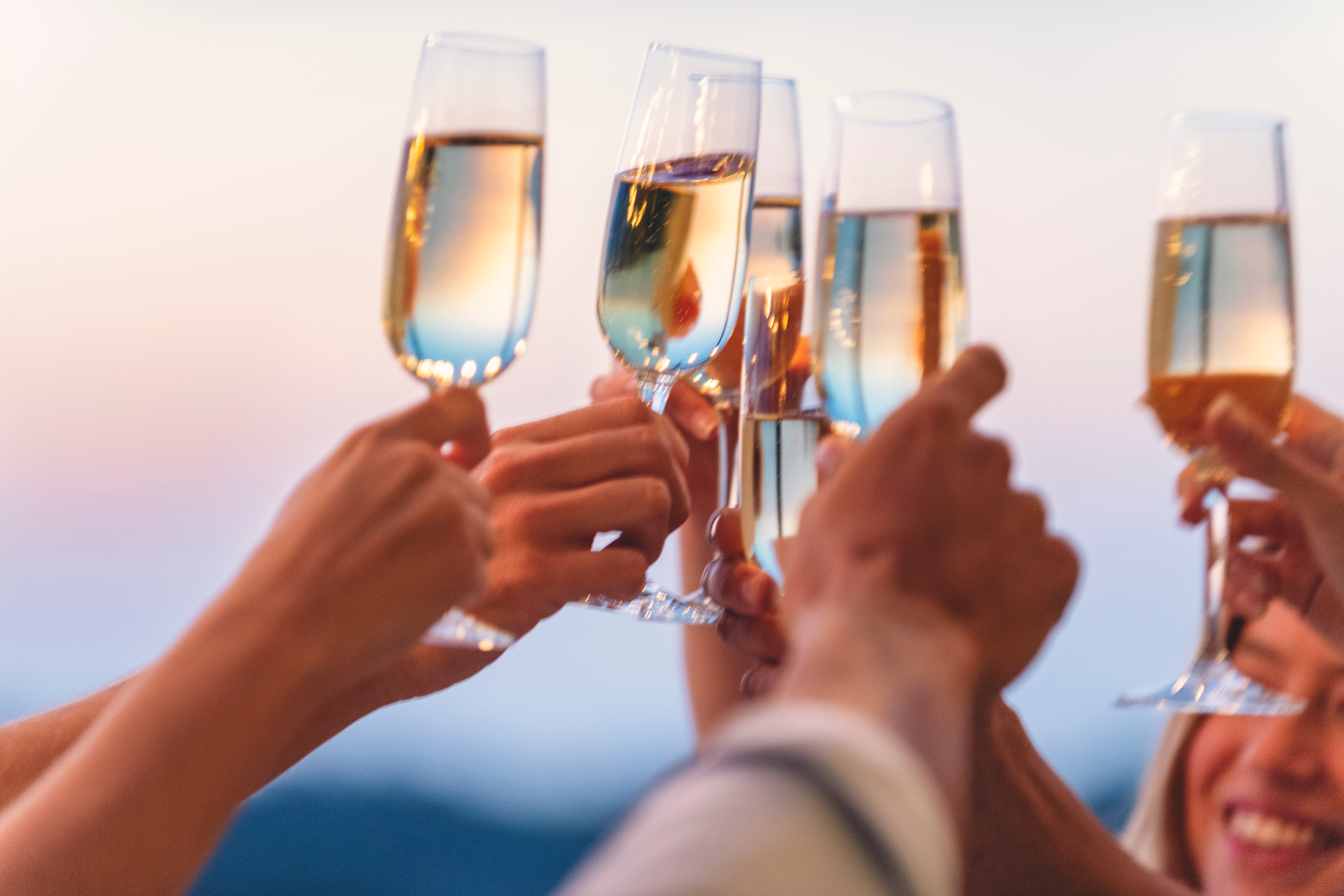 Group of friends toasting with champagne at sunset